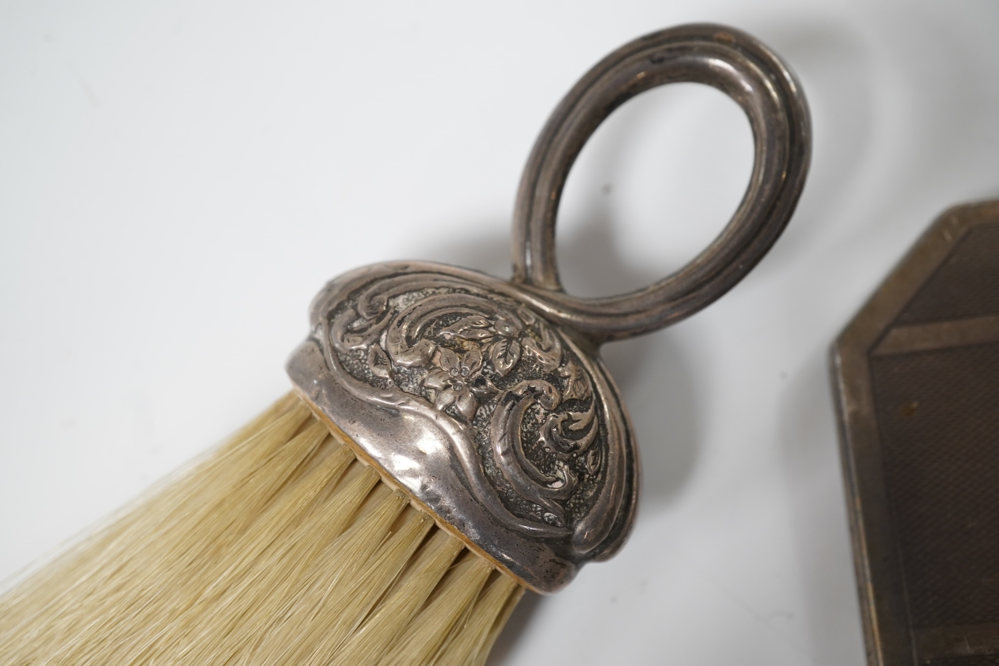 An Art Deco silver mounted hand mirror by Collett & Anderson, London, circa 1930, 22.7cm, together with a silver mounted crumb brush, clothes brush and an engine turned silver compact.